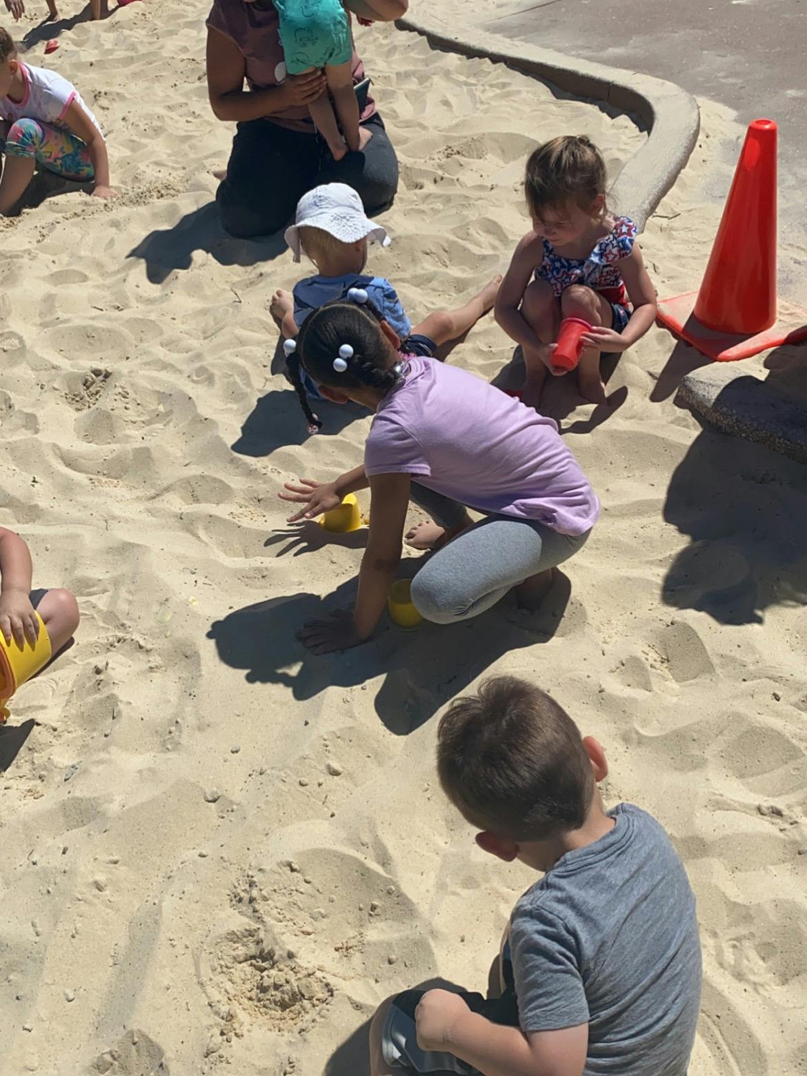 Children playing in a sandbox with sand toys