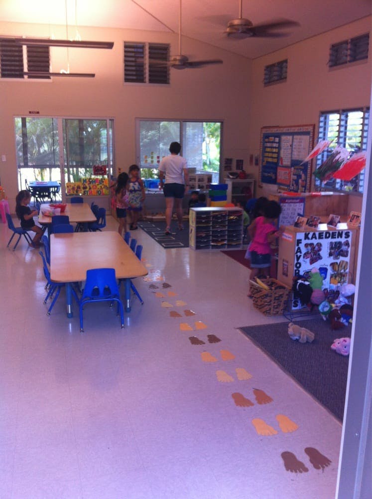 Adult and children in a classroom with tables and chairs
