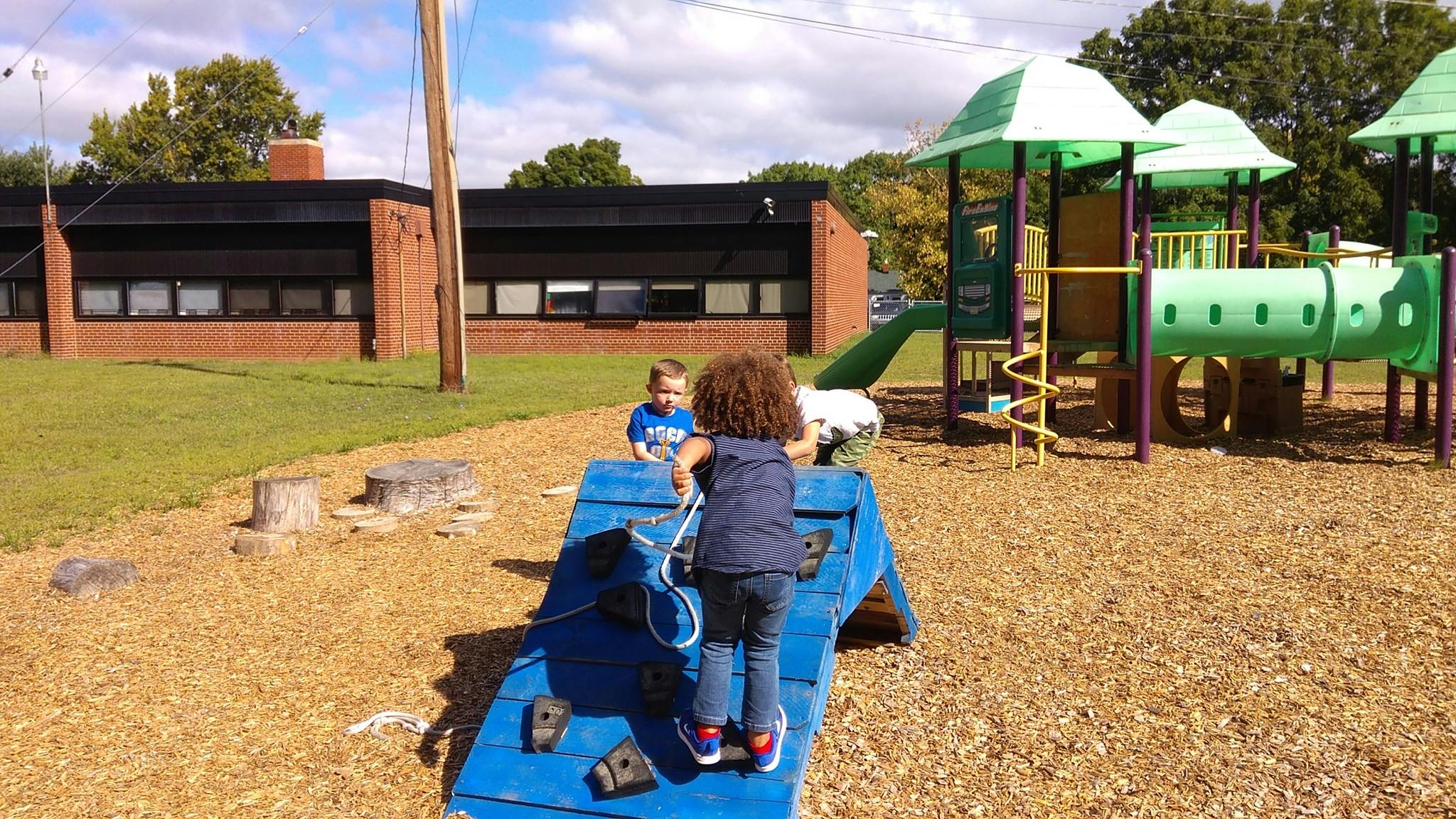 Child climbing on a blue playground structure