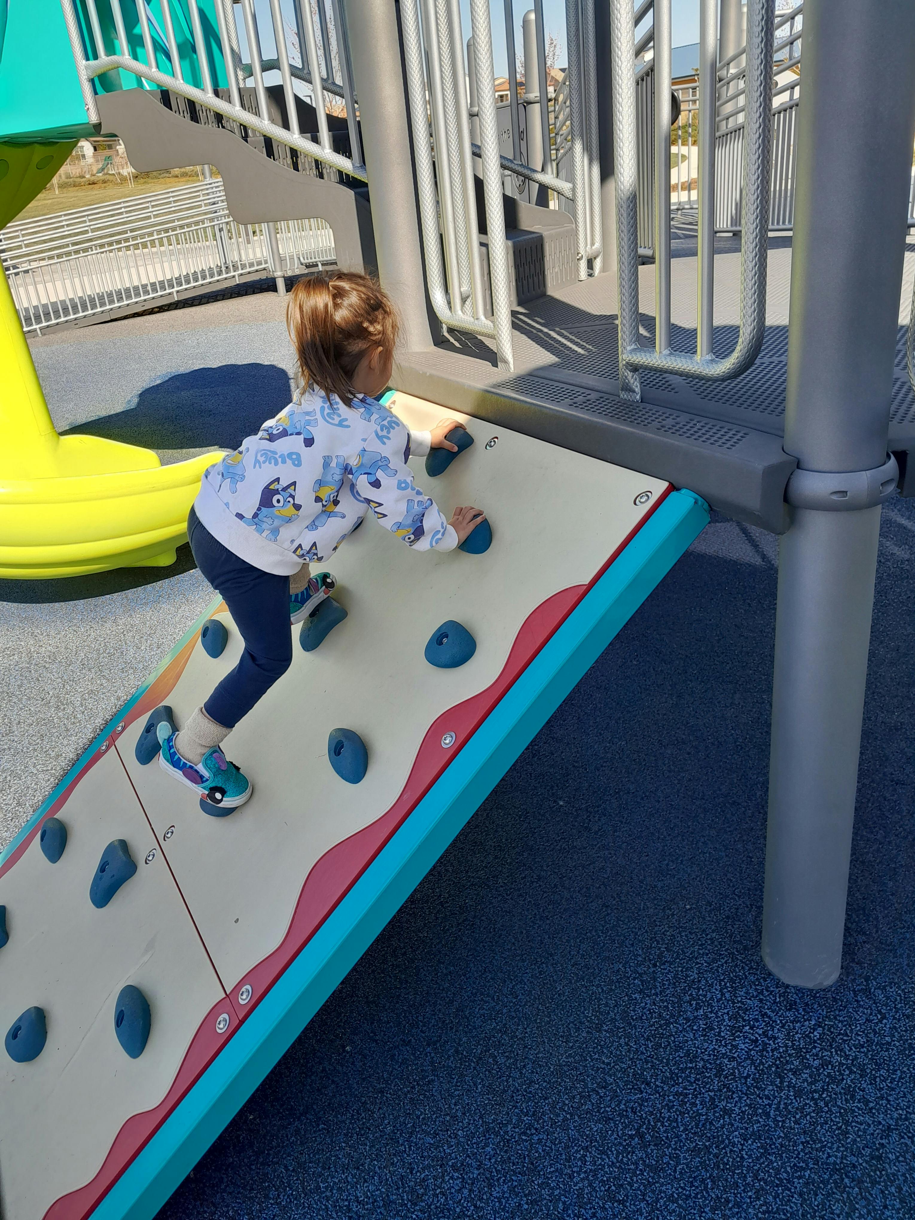 Child climbing a rock wall on a playground
