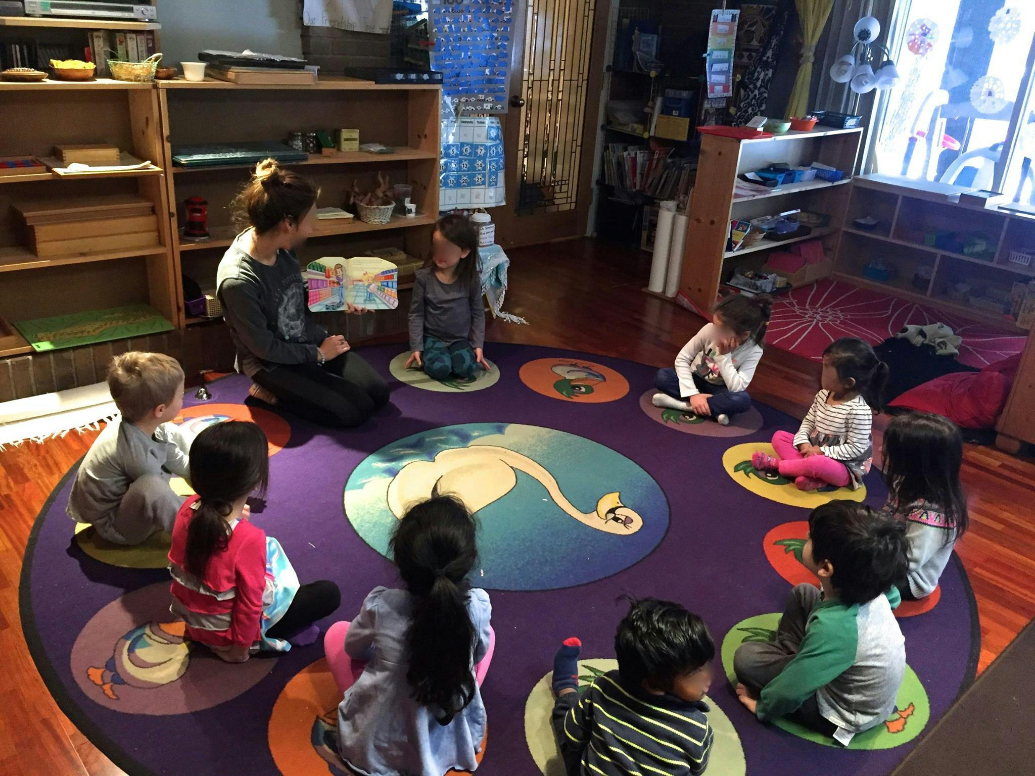 Adult and children sitting in a circle on a rug