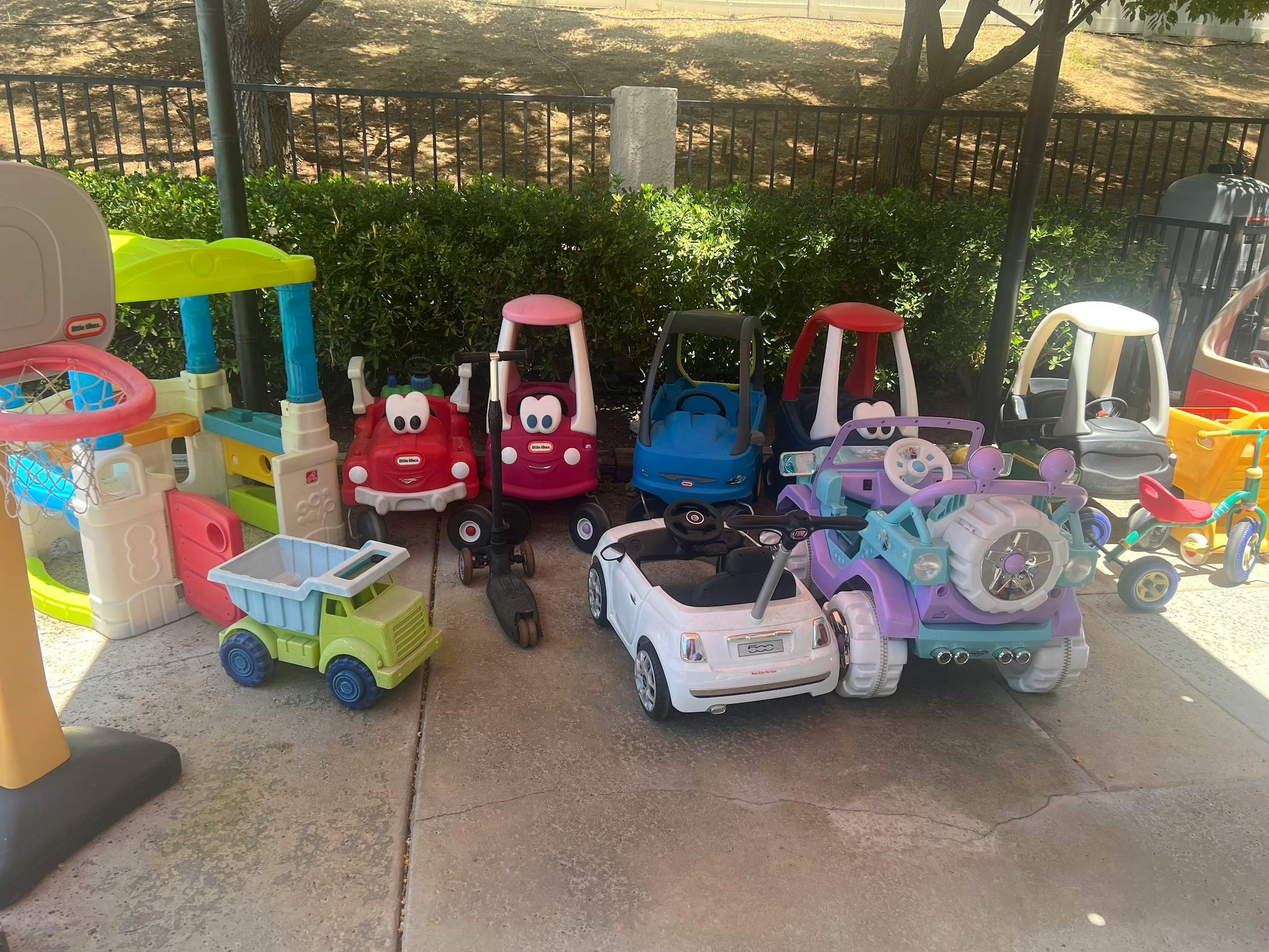 Collection of children's ride-on toys and play structures outdoors