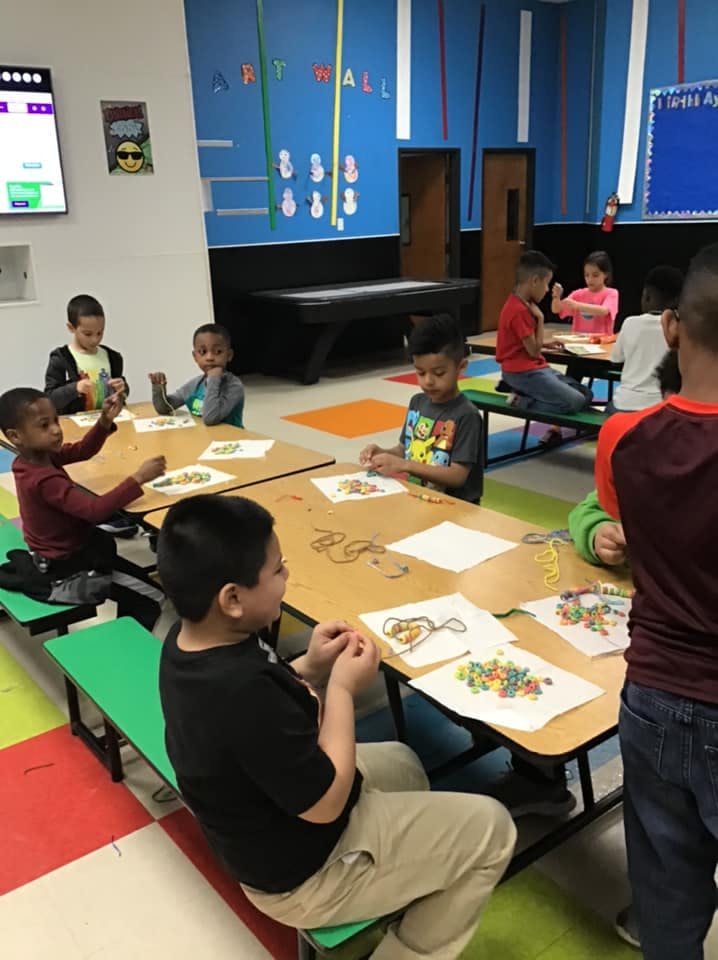 Children sitting at tables doing crafts