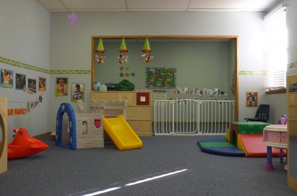 Playroom with a yellow slide, play castle, and soft play equipment