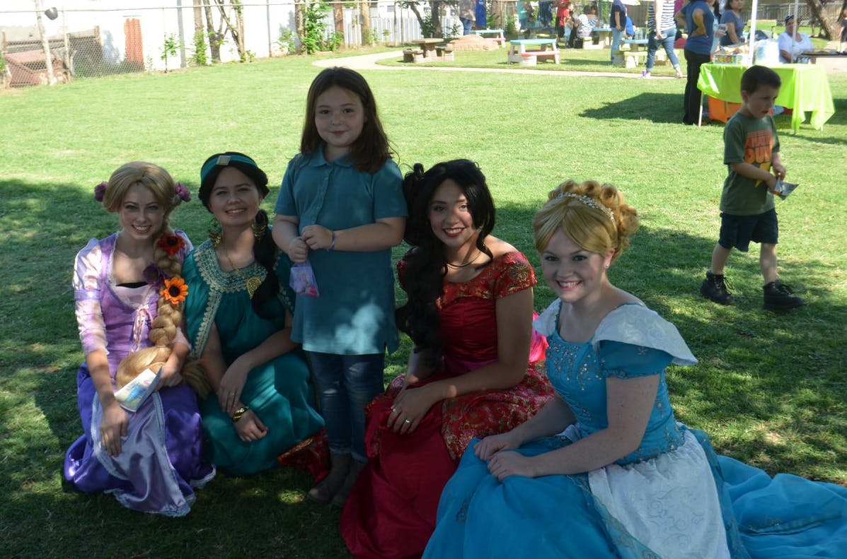 People in costumes and a child posing on grass