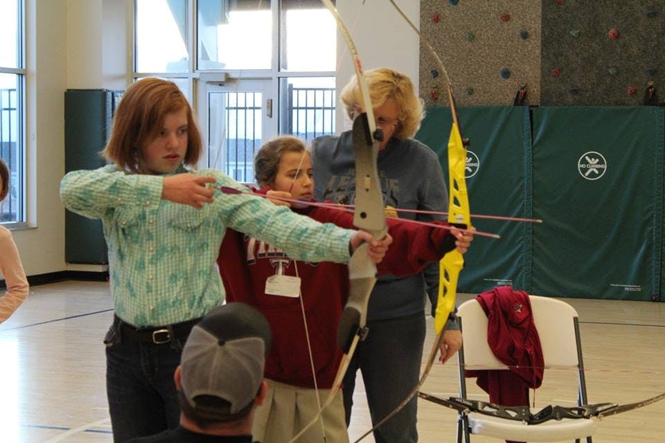 People learning archery with bows and arrows