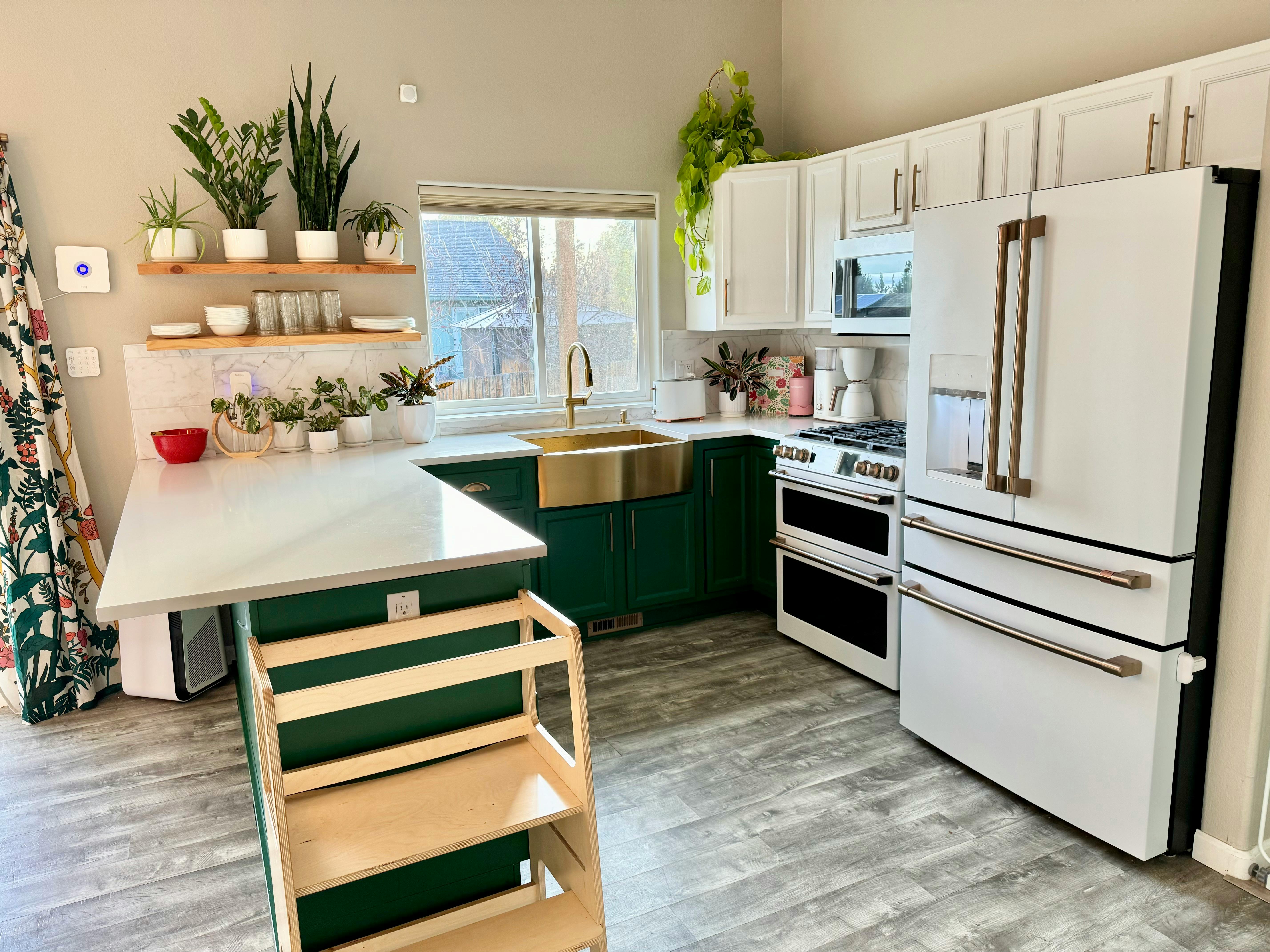 Kitchen with green cabinets, white appliances, and a gold sink