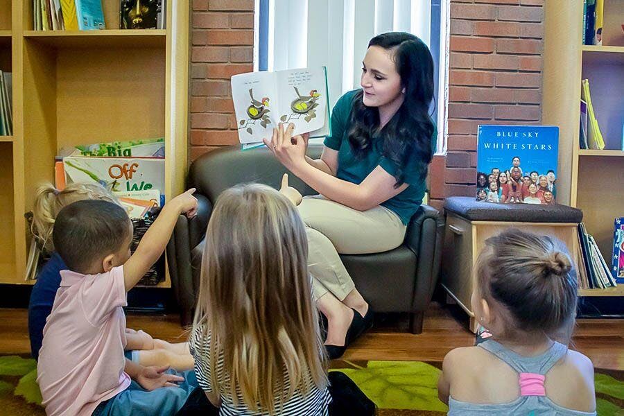 Person reading a book to children in a classroom