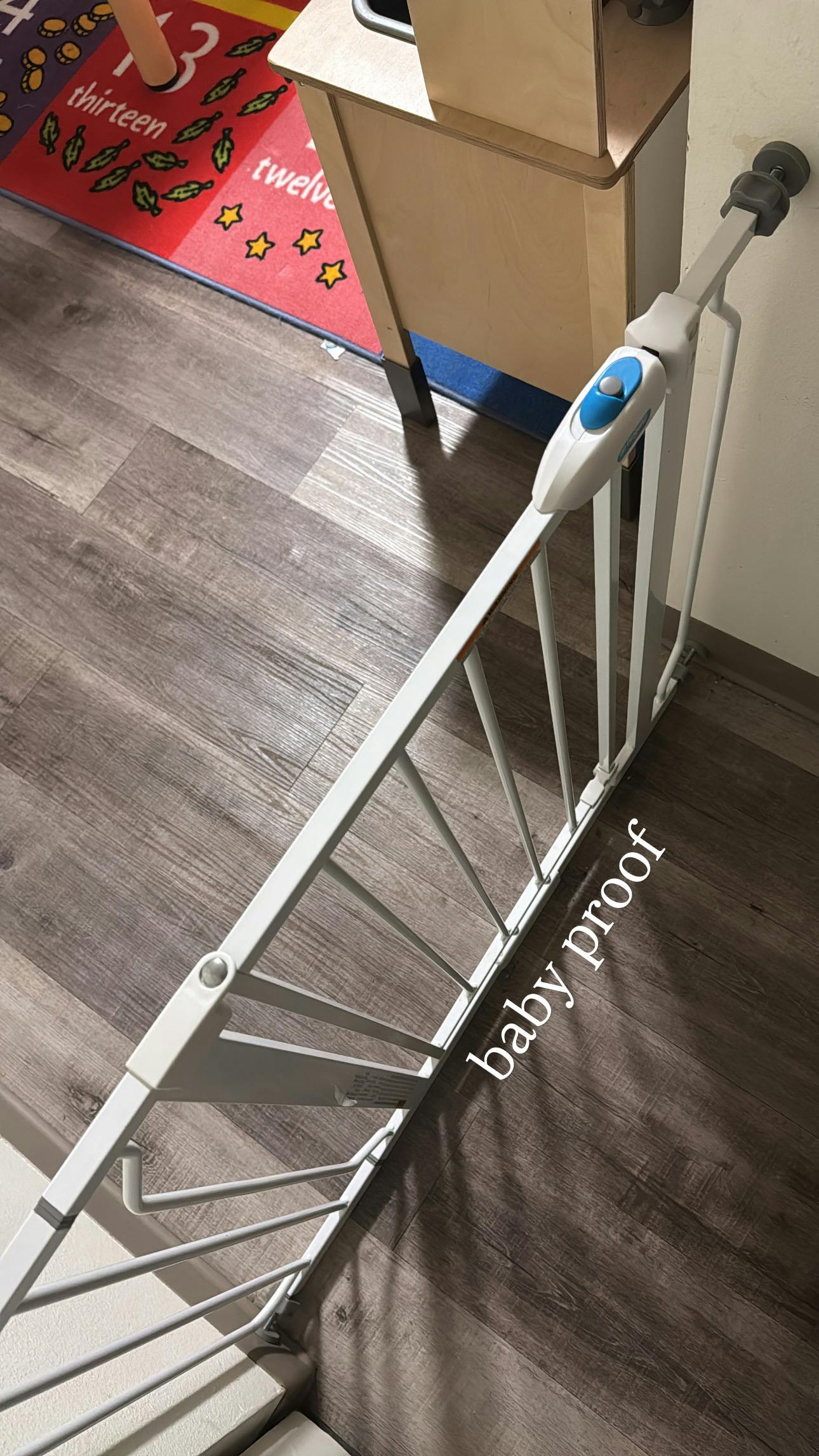 White baby gate with a blue button