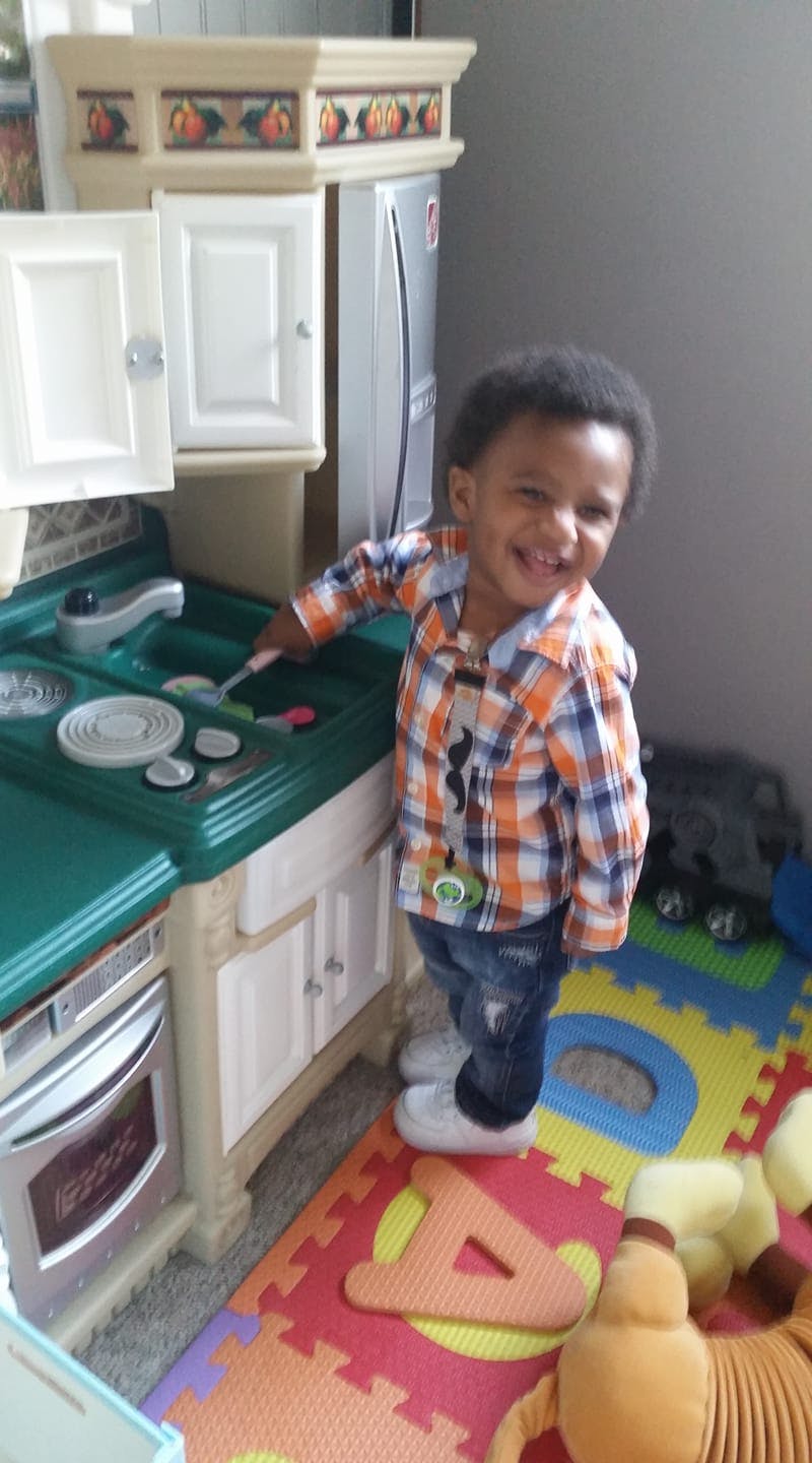 Child playing with a toy kitchen set