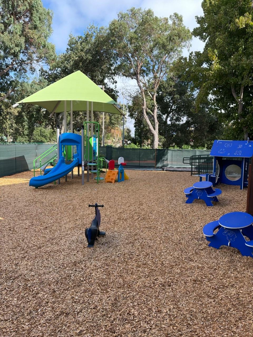 Playground with climbing structures, slides, and small tables