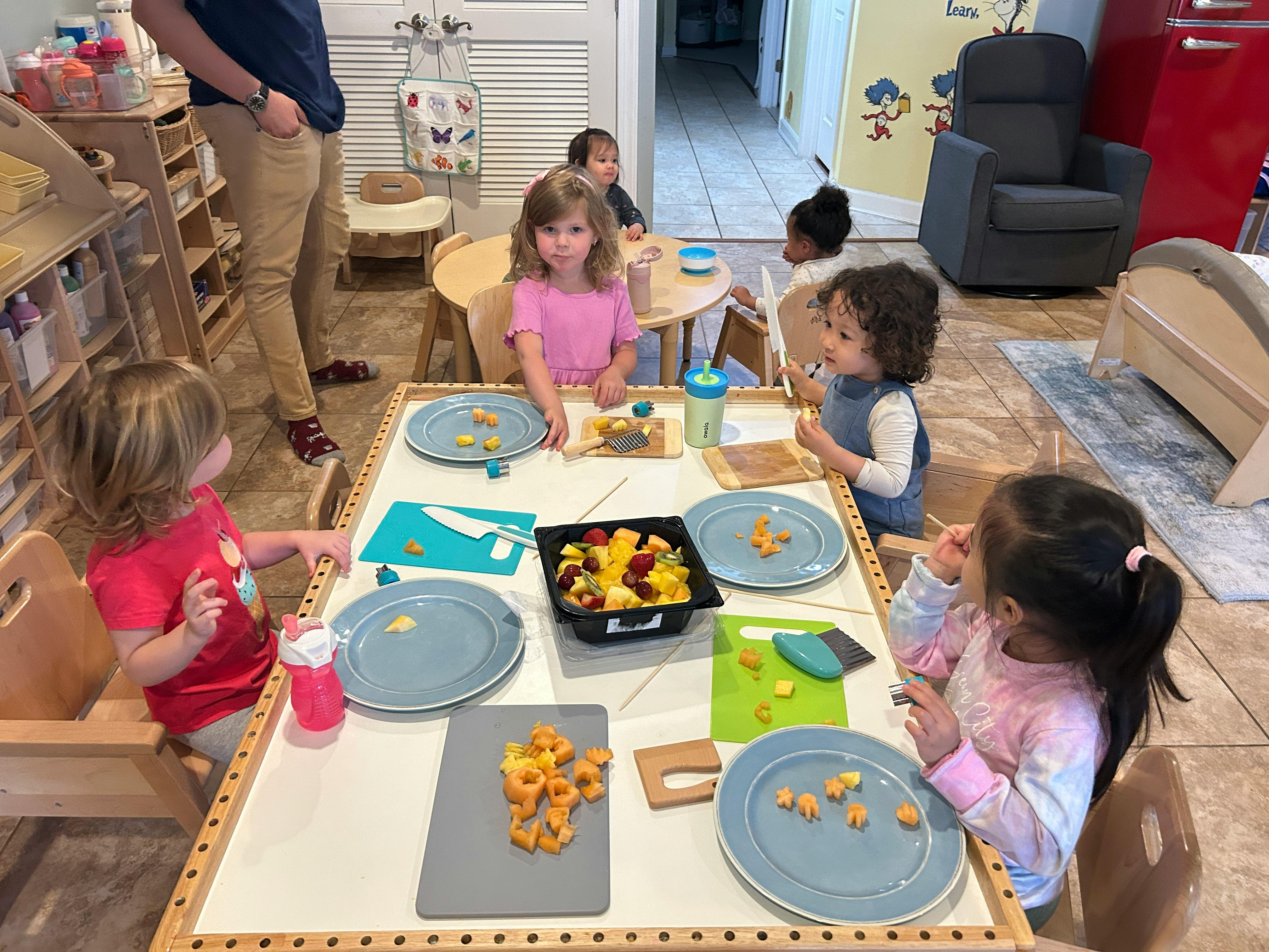 Children sitting at tables with plates of food