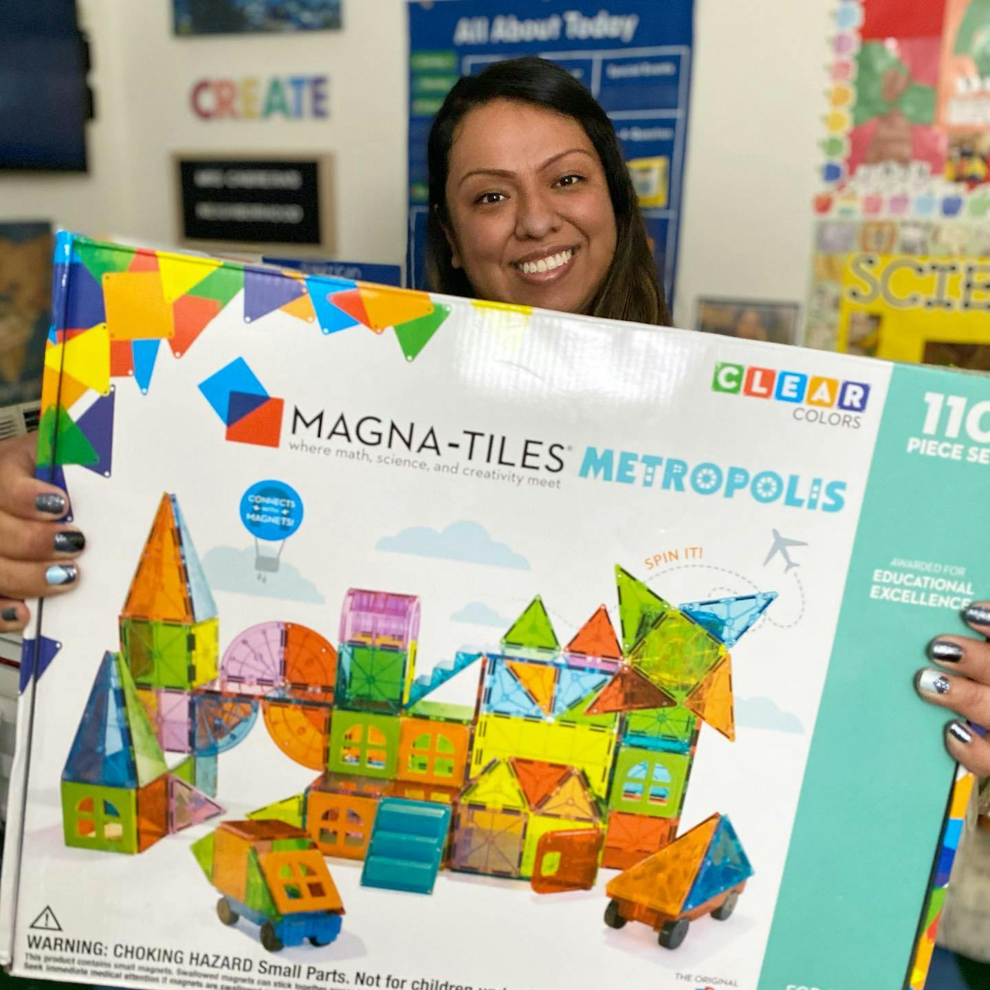 Person holding a box of Magna-Tiles Metropolis building toys