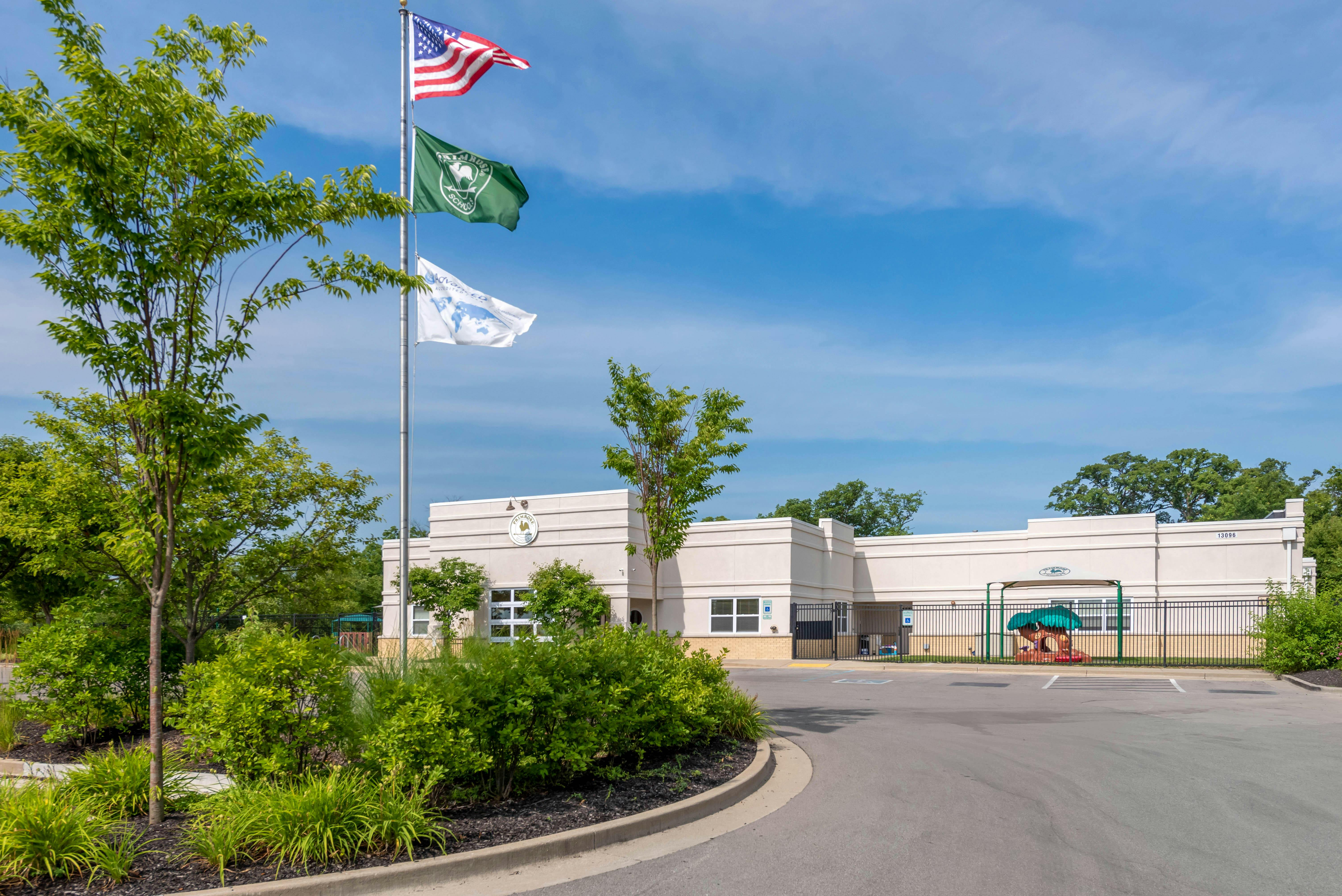 Building exterior with flags and a small playground