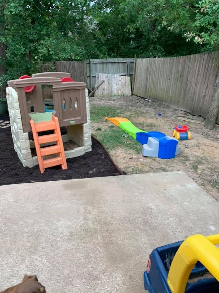 Playhouse with a ladder and a slide in a backyard