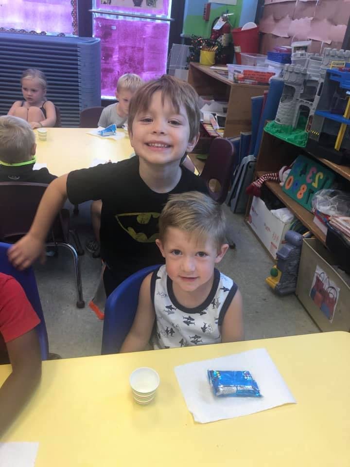 Two children sitting at a table in a classroom