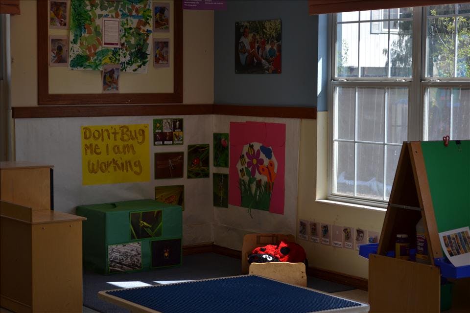 Children's classroom with artwork on walls, a window, and furniture