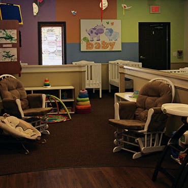 Nursery room with cribs, rocking chairs, and play items