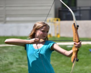 Child aiming a bow and arrow