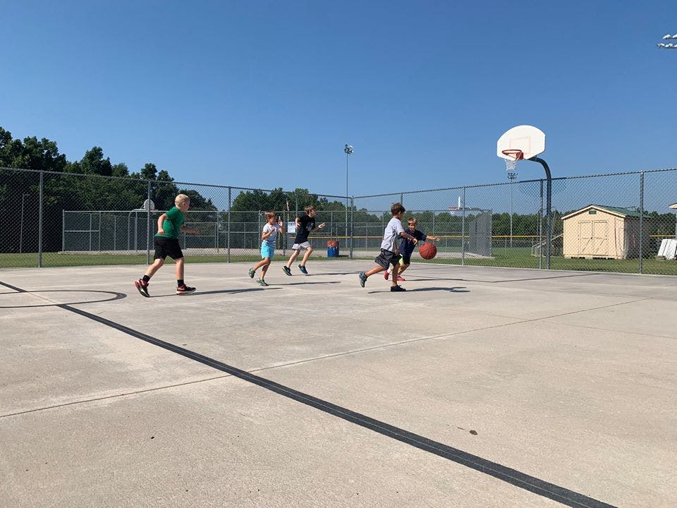 Children playing basketball on an outdoor court
