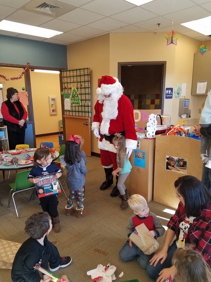 Santa Claus standing with children in a room