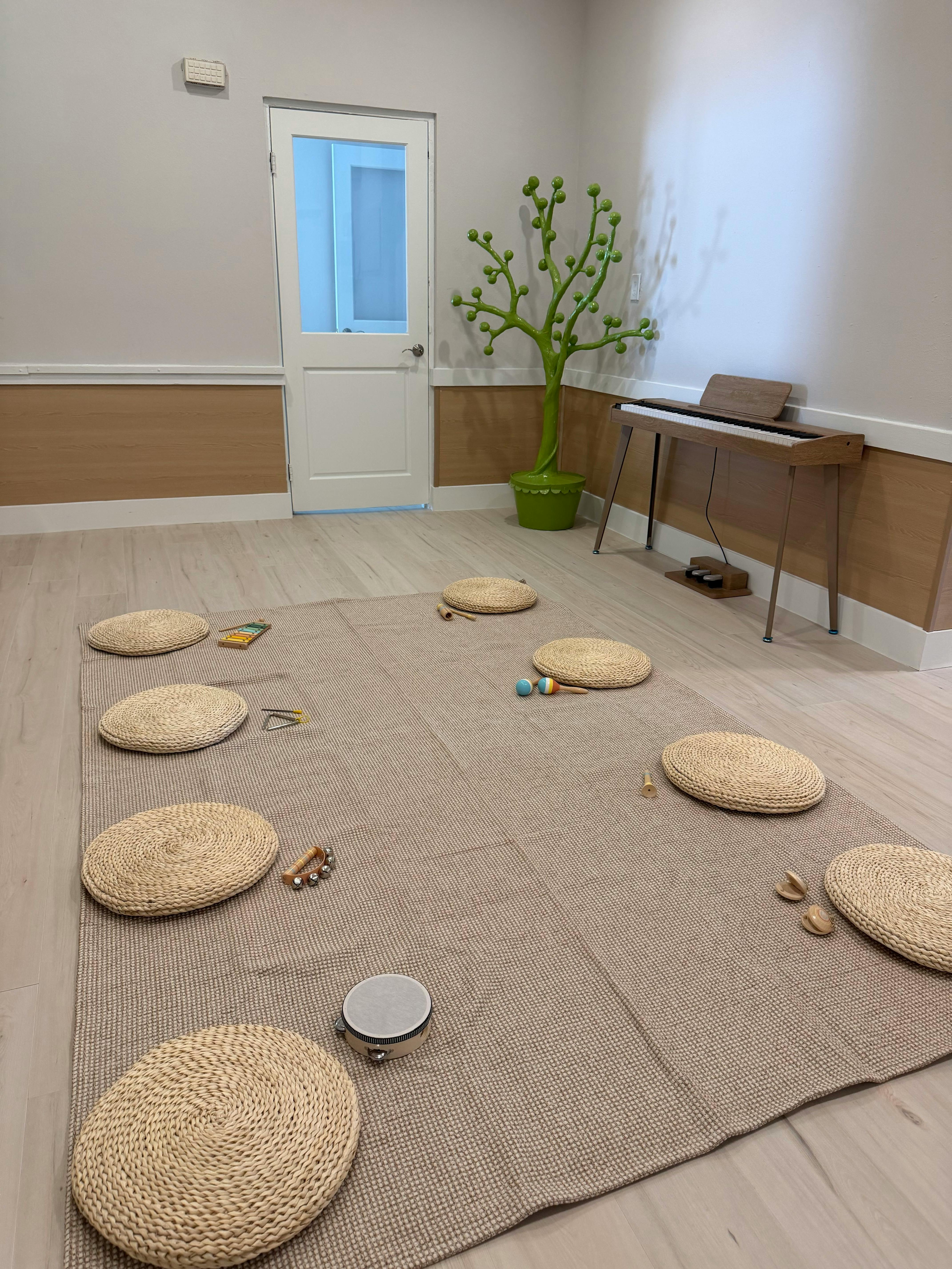 Round woven floor cushions arranged on a rug with musical instruments