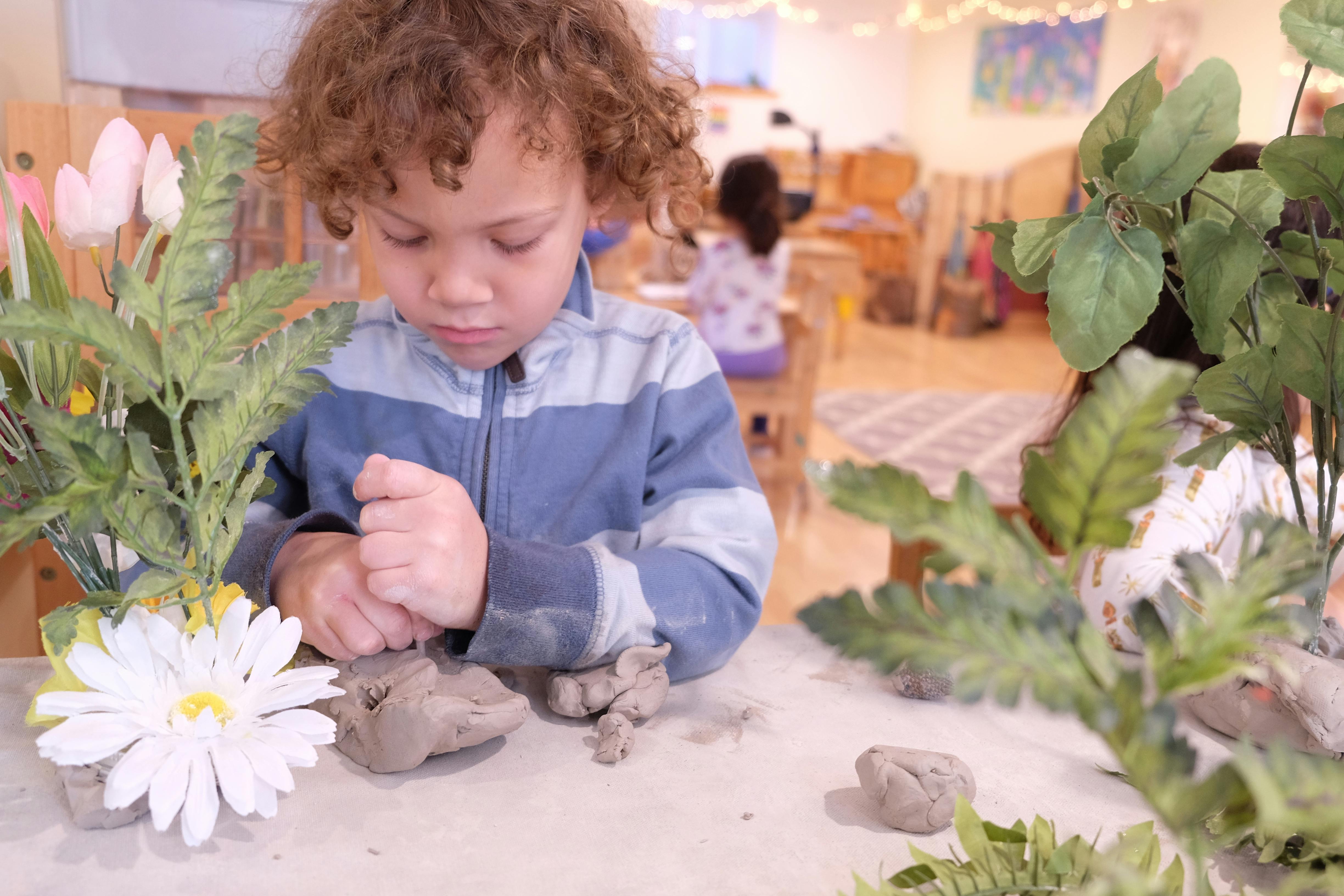Child playing with clay in a classroom