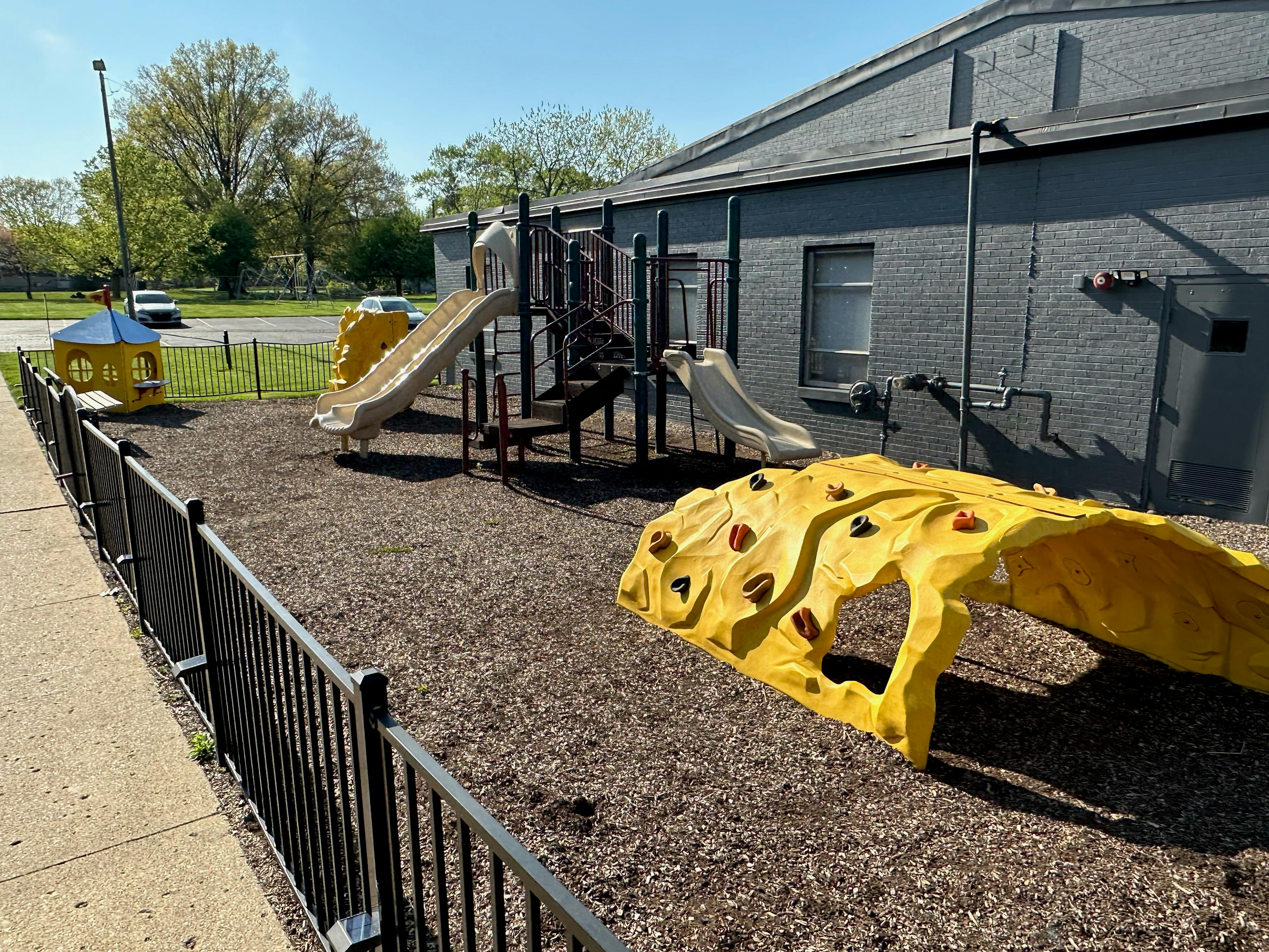Playground with slides, climbing structure, and yellow tunnel