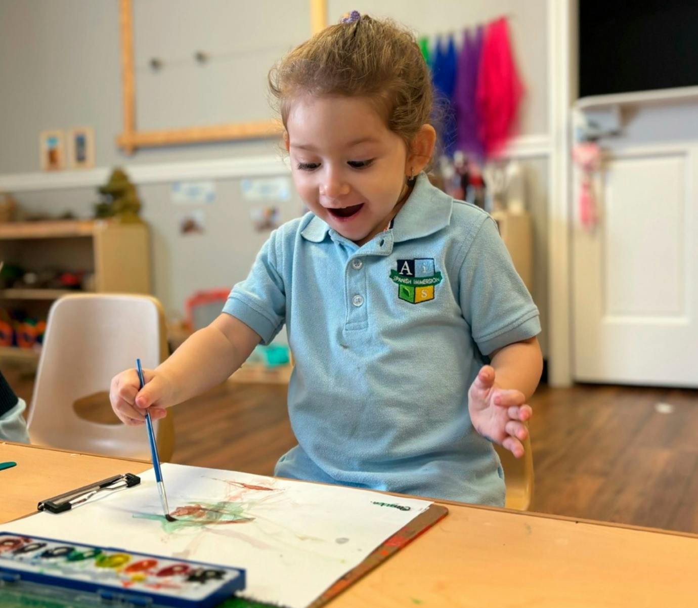 Child painting with watercolors at a table