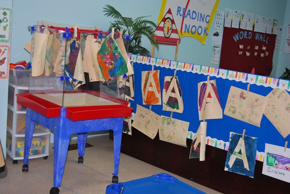 Classroom with a sensory table and children's artwork on display