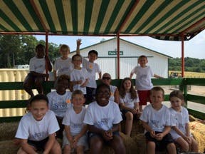 Group of children and adults sitting in a wagon