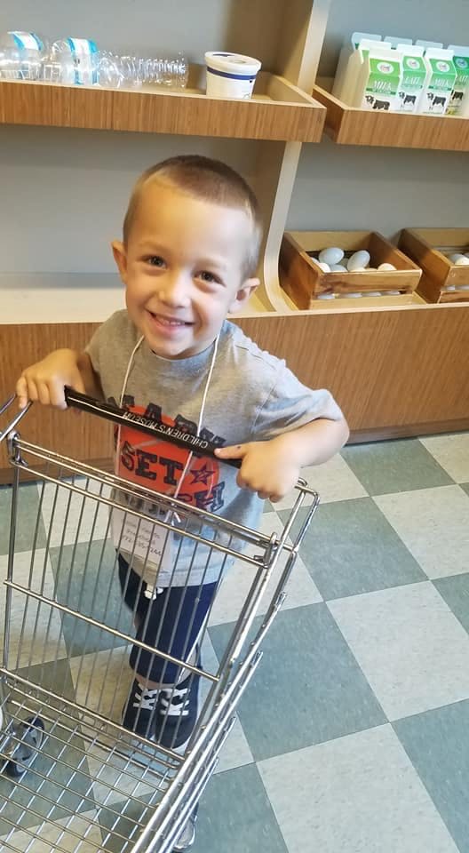 Child pushing a small shopping cart