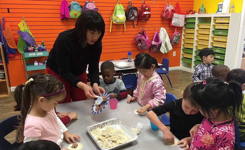 Person helping children with an activity at a table