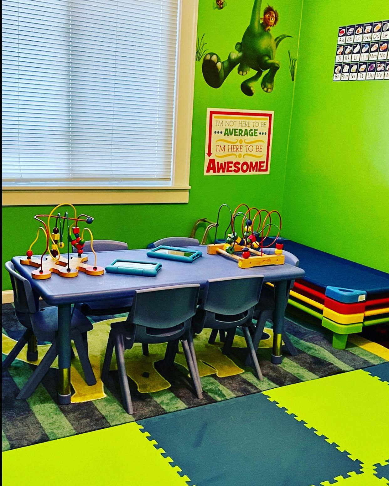 Children's play area with small table and chairs, bead mazes, and a mat