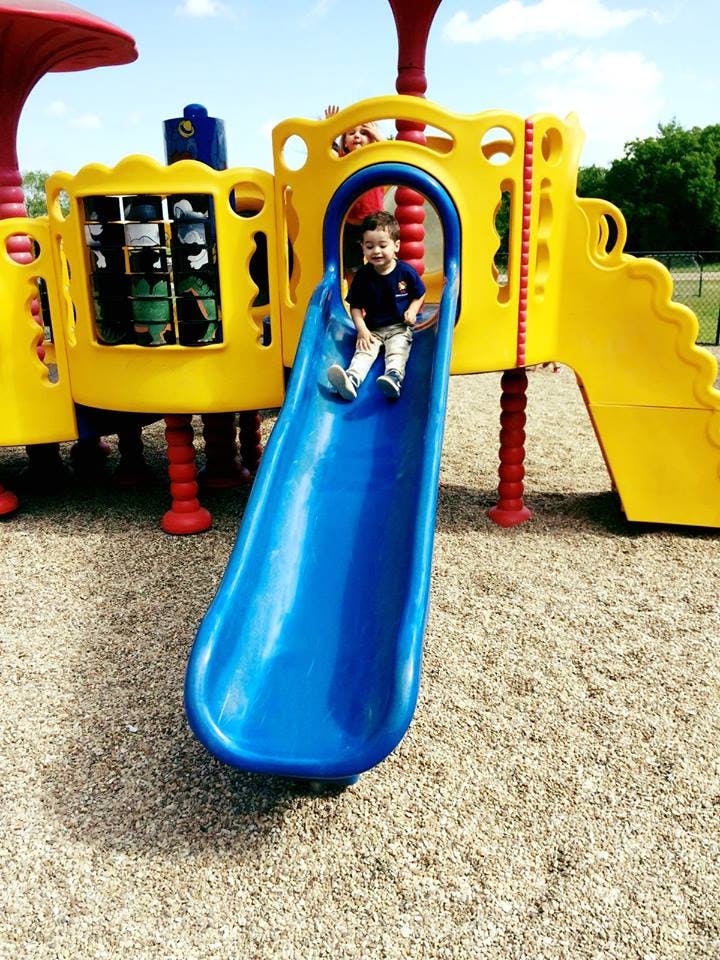 Child on a blue slide at a playground