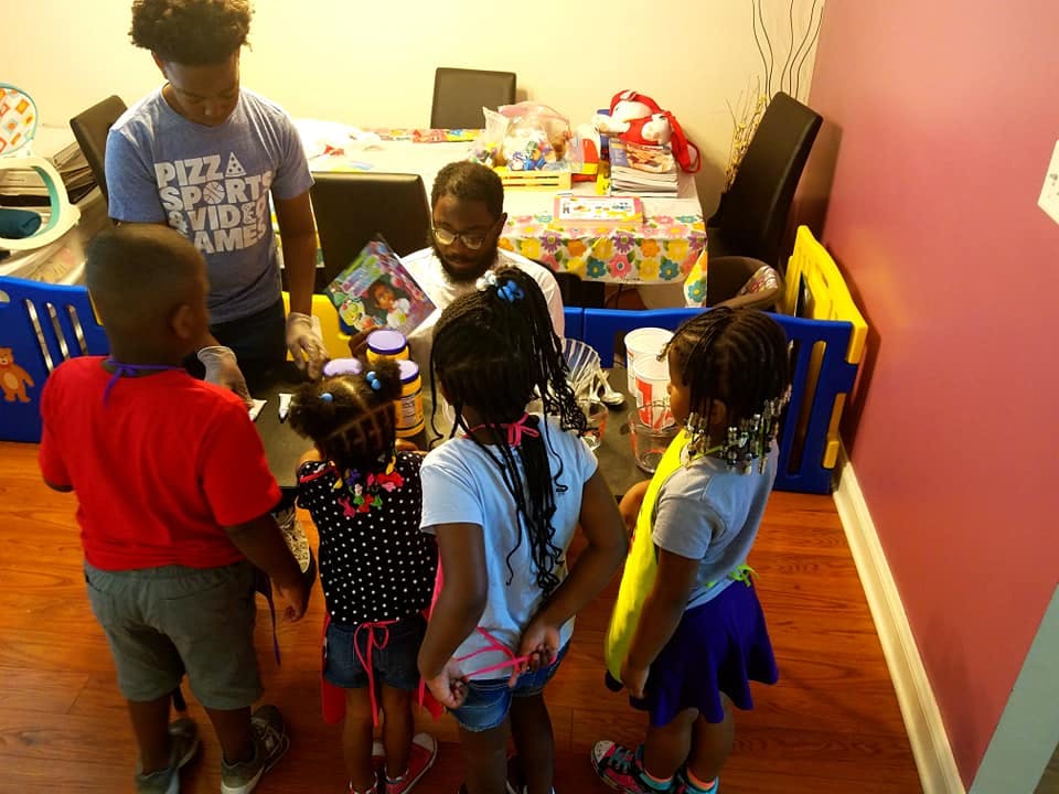 Two people reading to a group of children