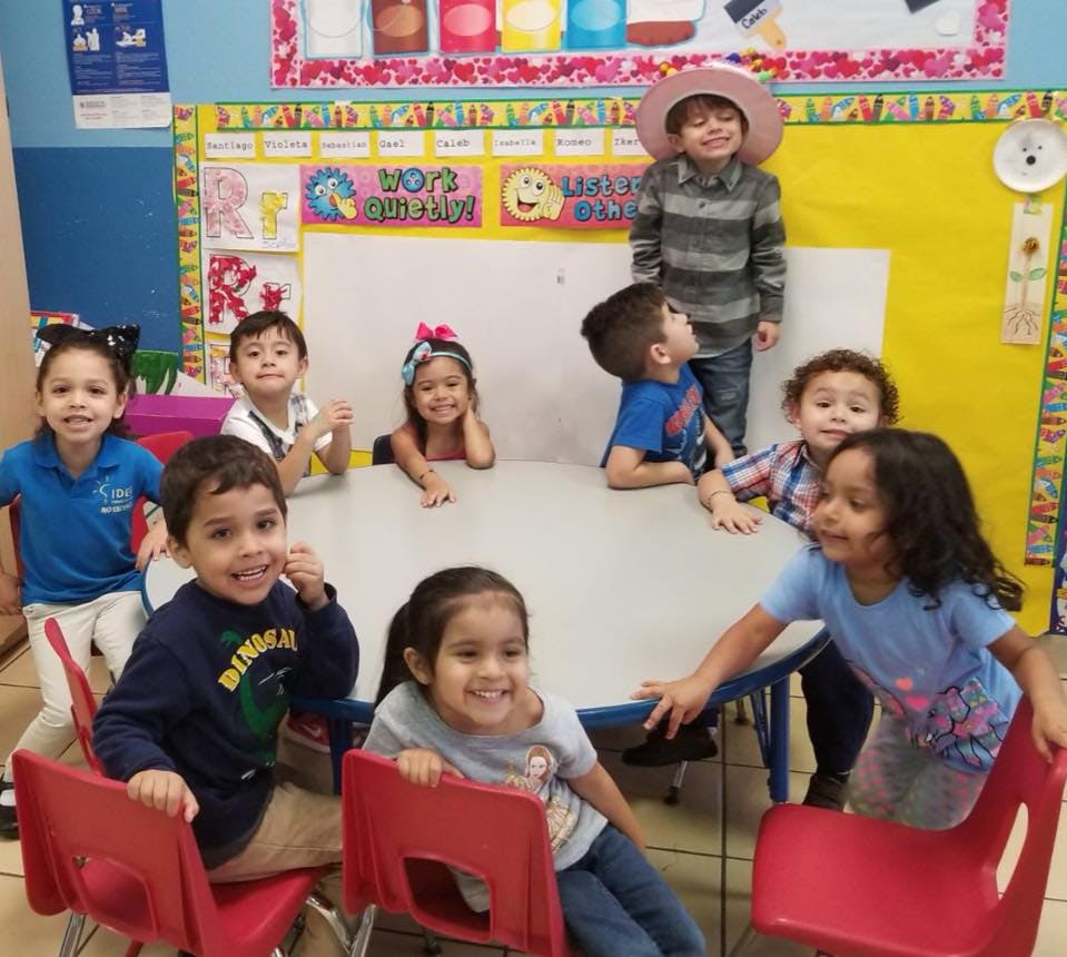 Group of children gathered around a table in a classroom