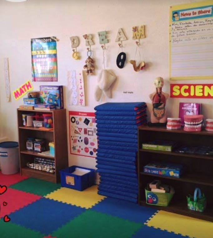 Classroom with colorful floor mats, shelves, and educational posters