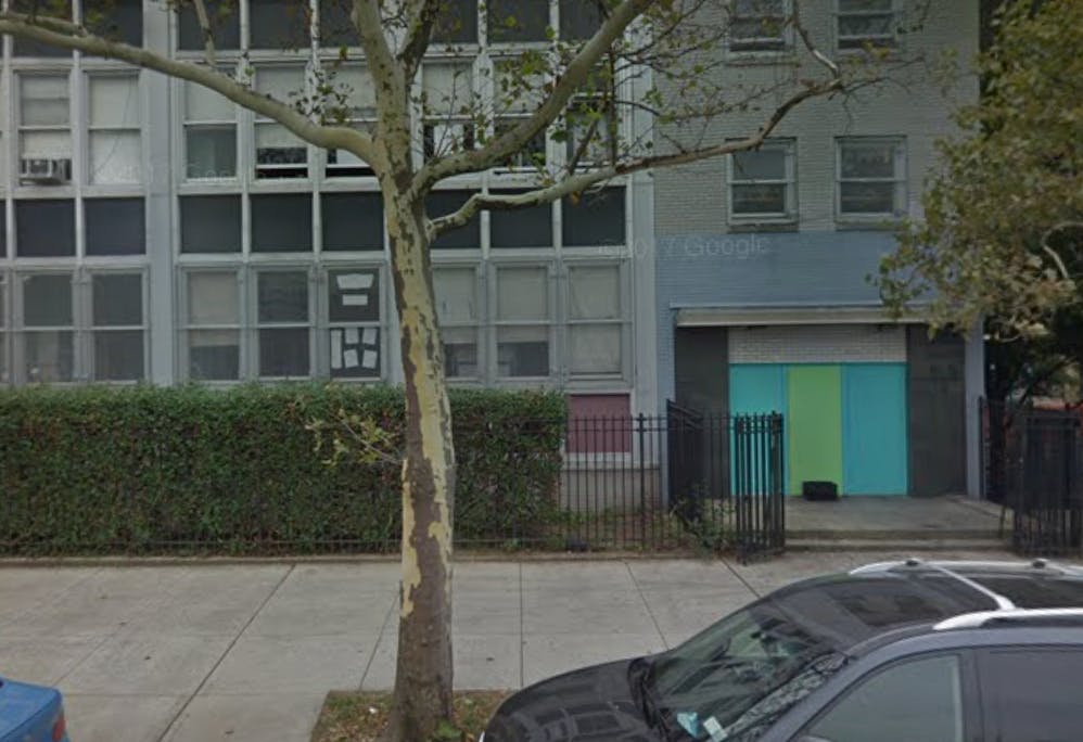 Building with a tree and parked cars in front