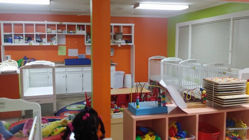 Nursery room with cribs, shelves, and toys