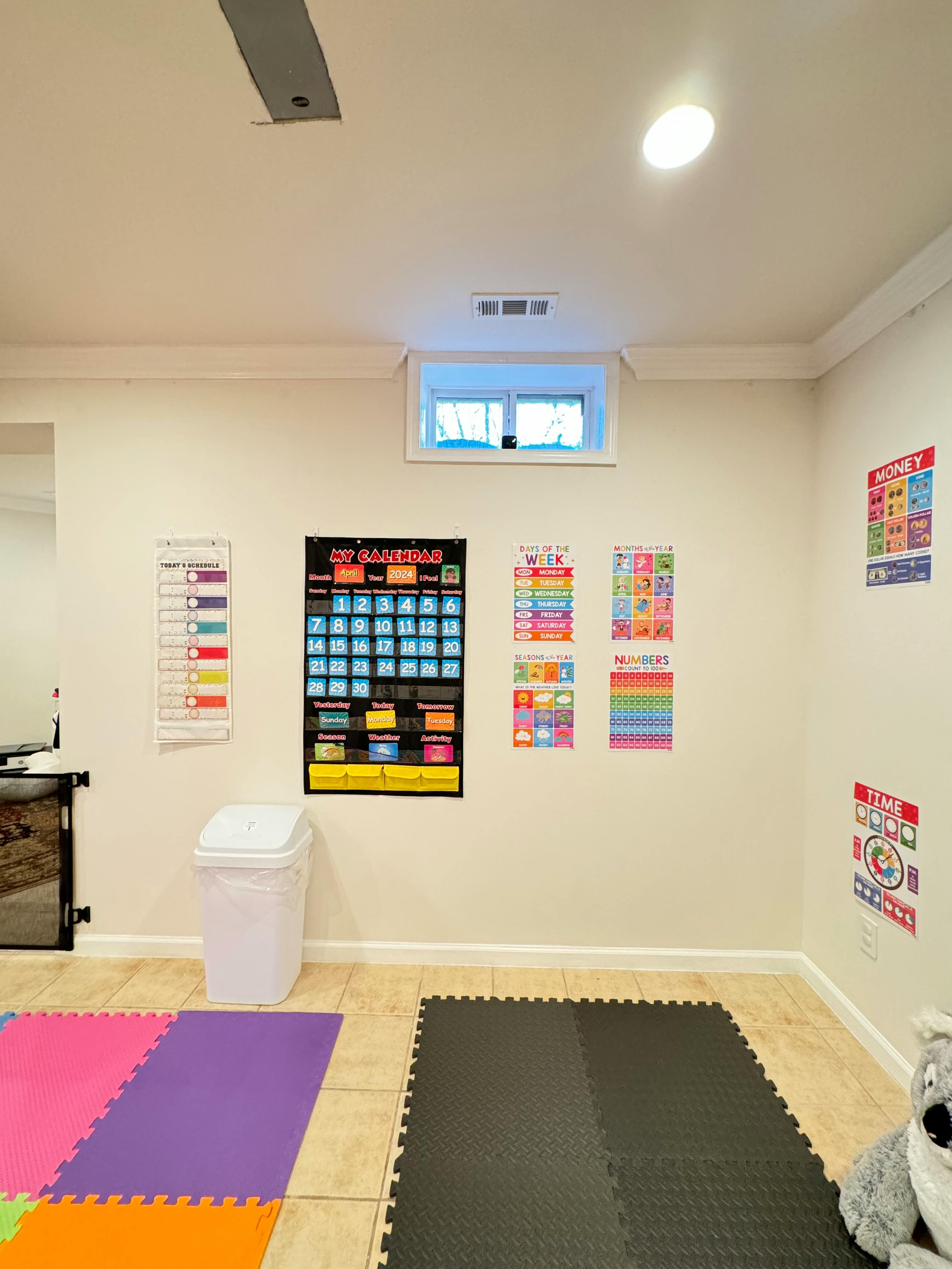 Wall with educational charts, a window, and floor mats