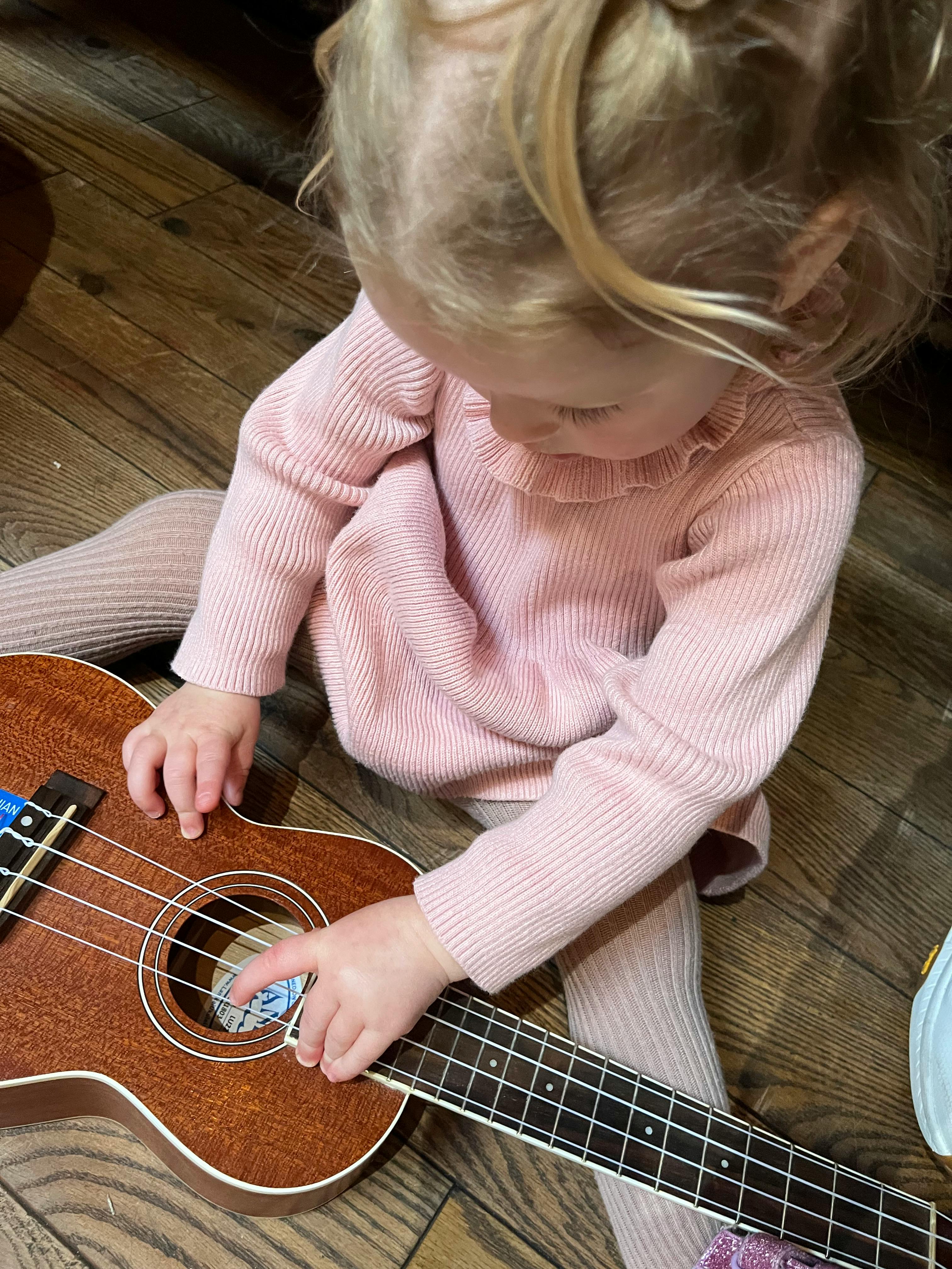 Child playing with a ukulele