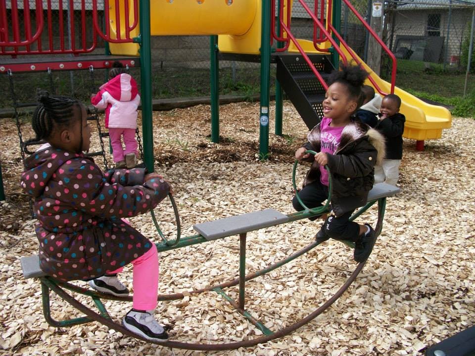 Two children on a seesaw at a playground