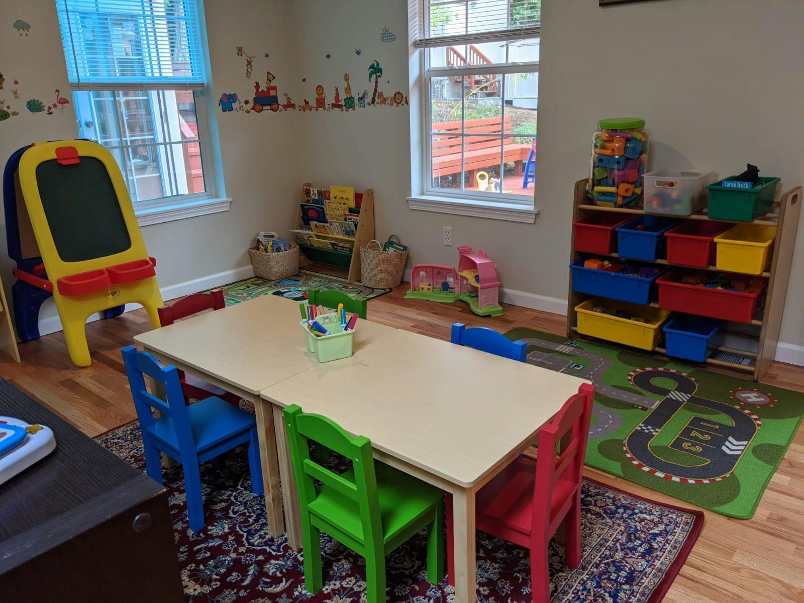 Playroom with a table and chairs, toy storage, and an easel