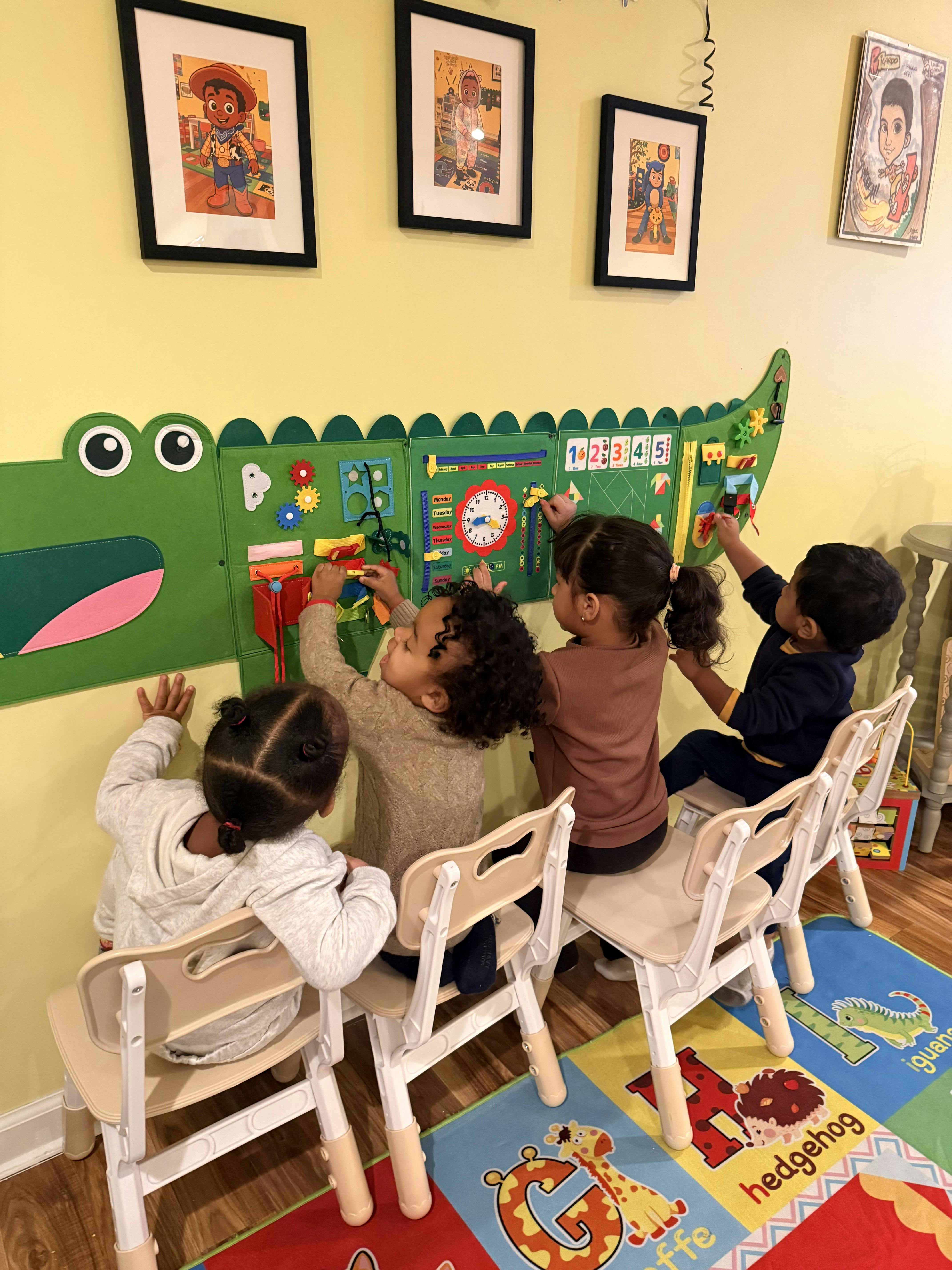 Four children playing with a large green activity board on a yellow wall