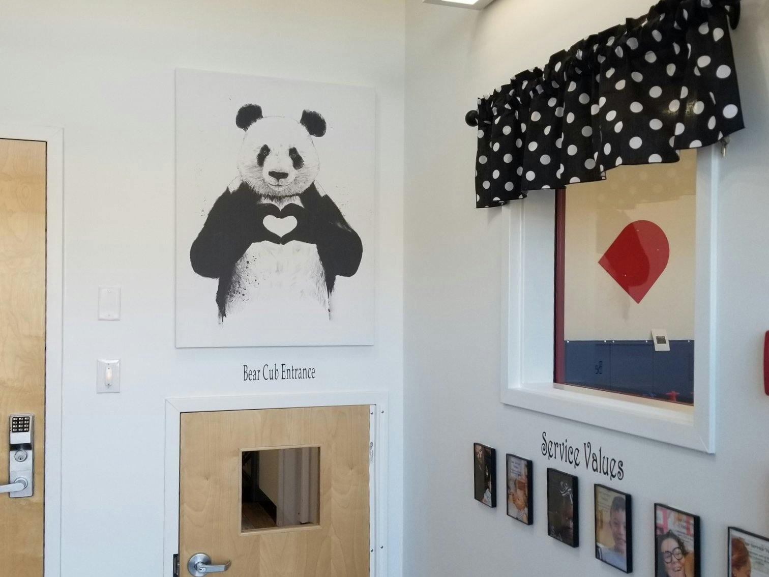 Panda bear artwork above a door labeled "Bear Cub Entrance" next to a window