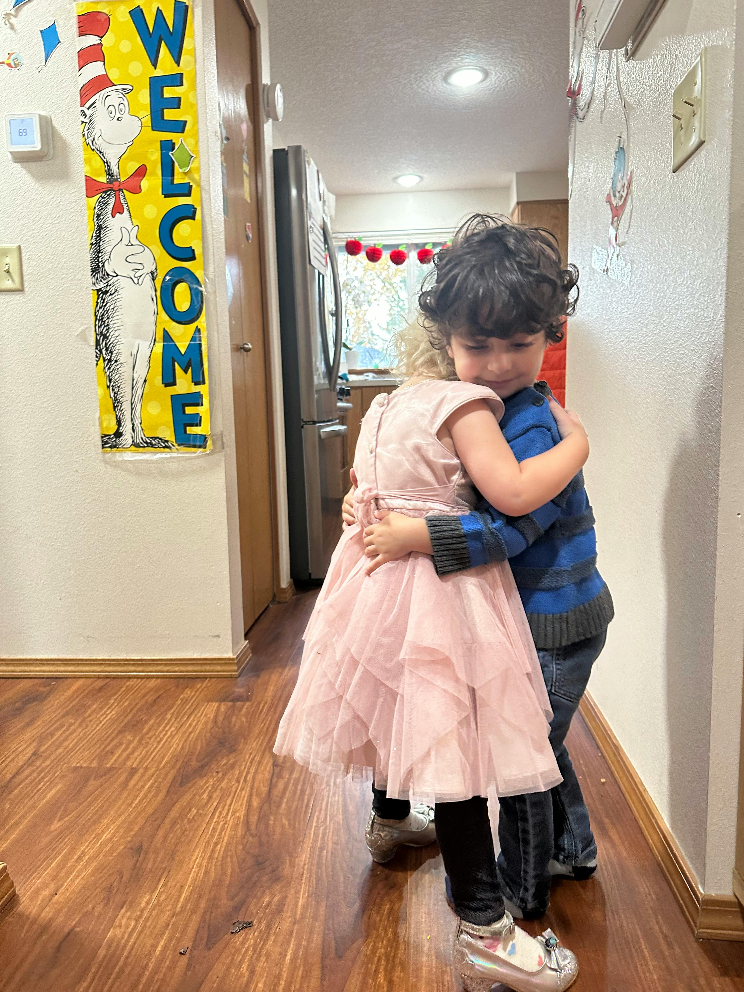 Two children hugging in a hallway
