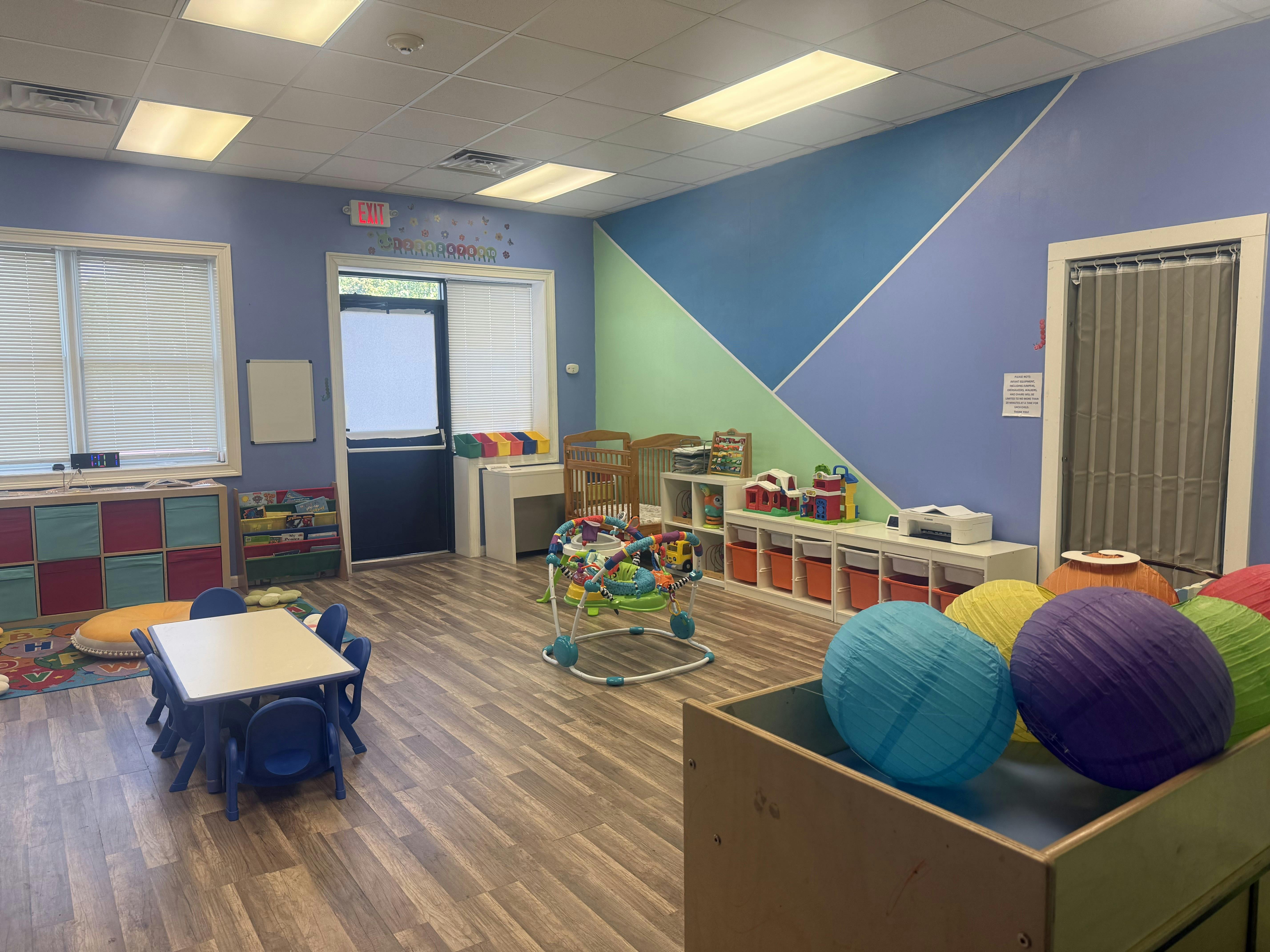 Childcare room with play equipment furniture and colorful lanterns