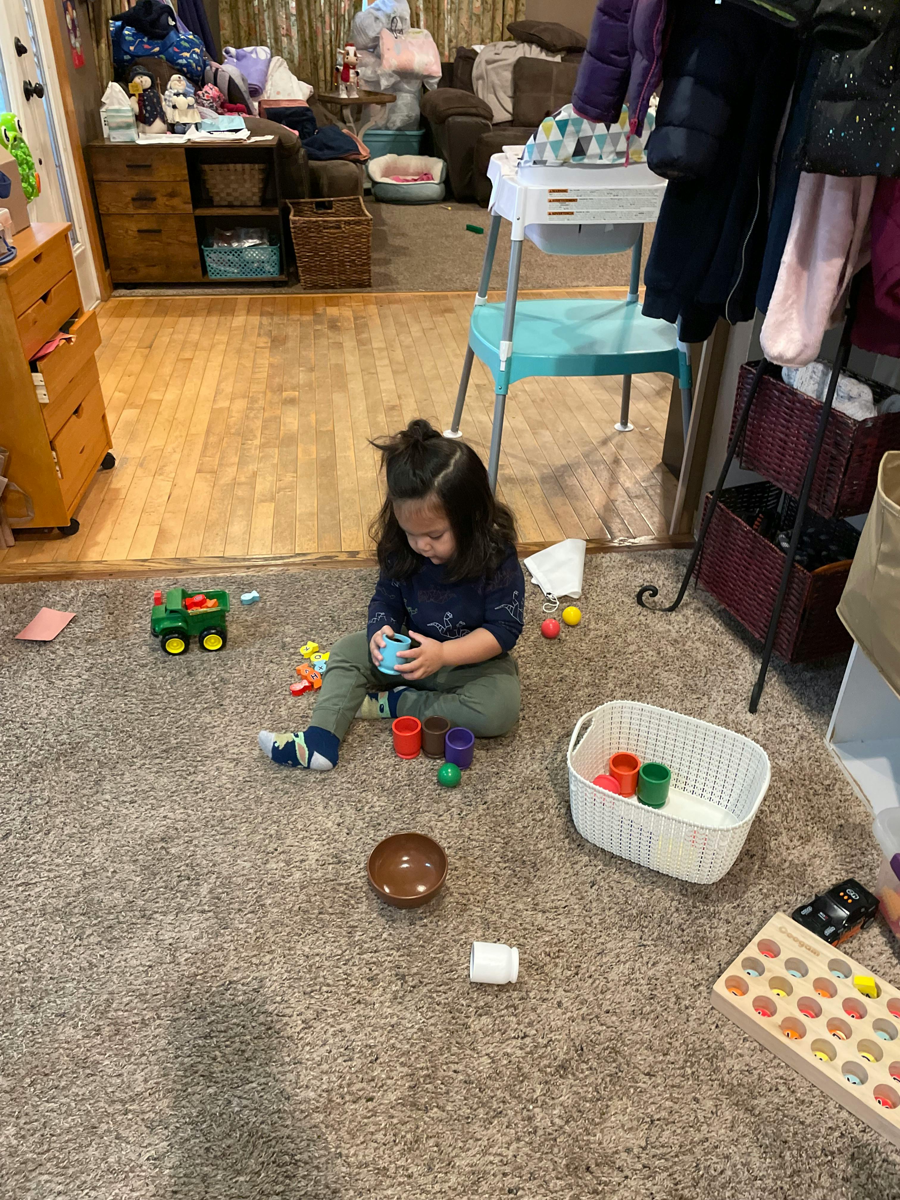 Child sitting on carpet playing with toys