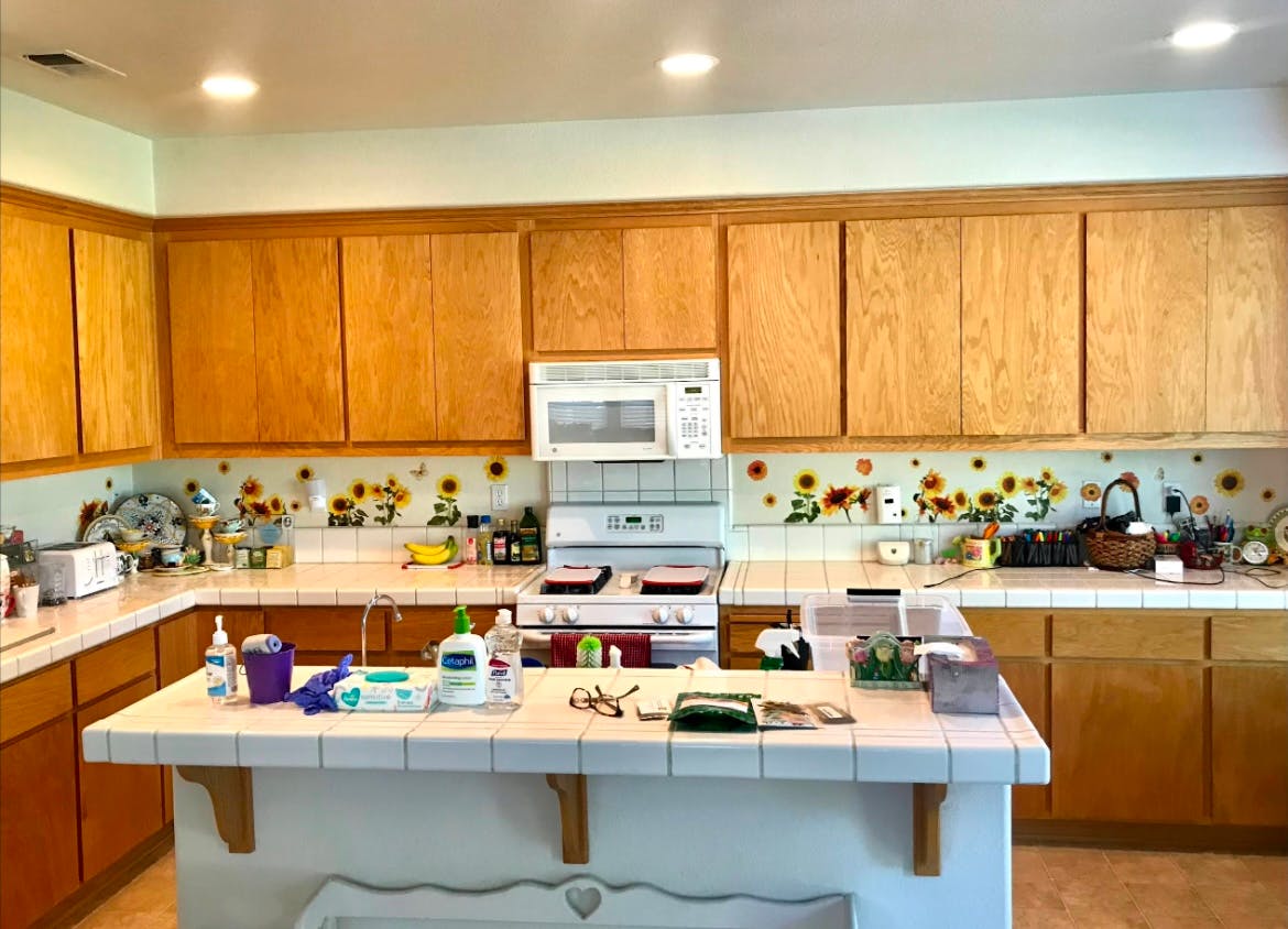 Kitchen with light wood cabinets, white countertops, and a white stove and stainless steel stove
